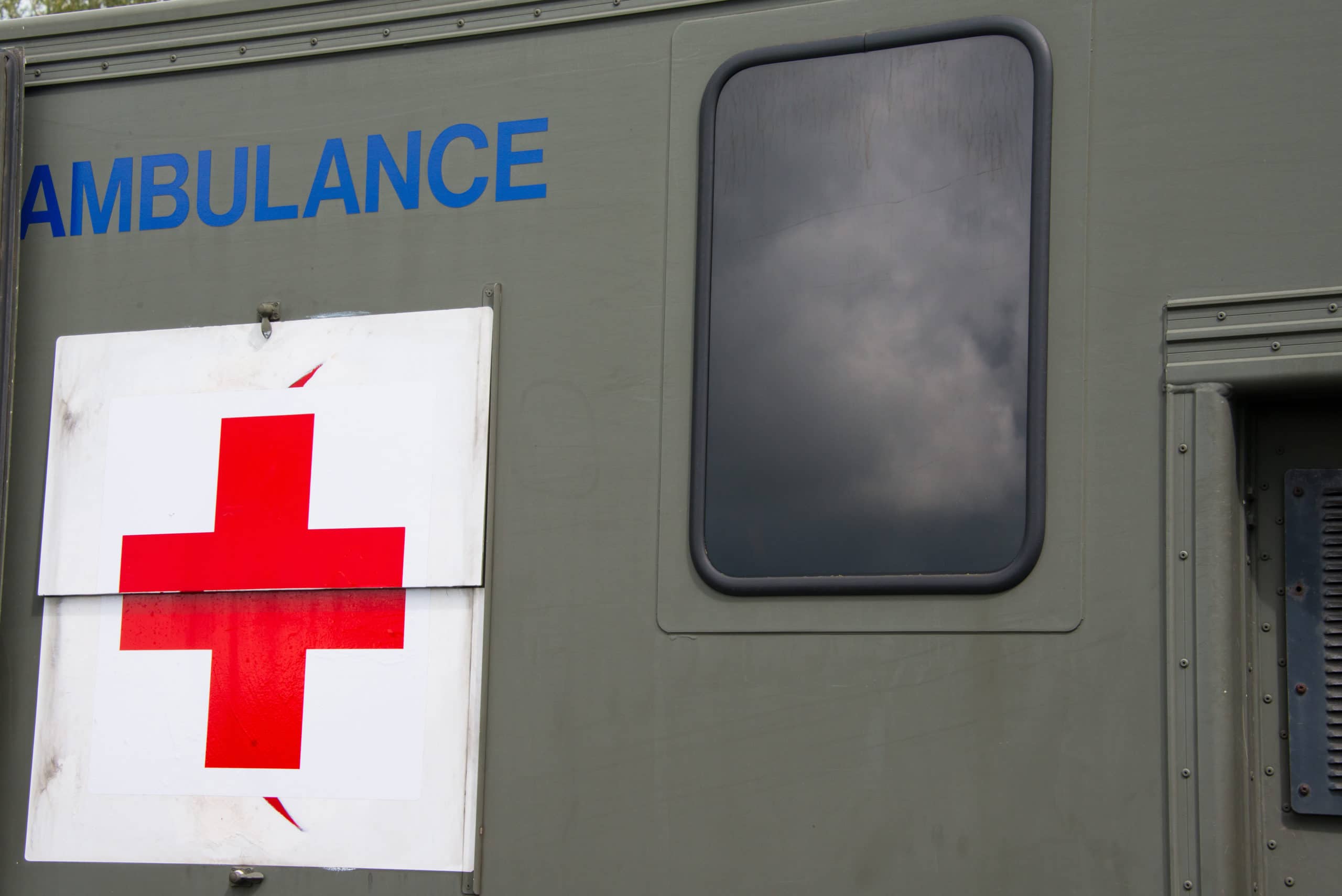 picture of an old military ambulance with red and white cross