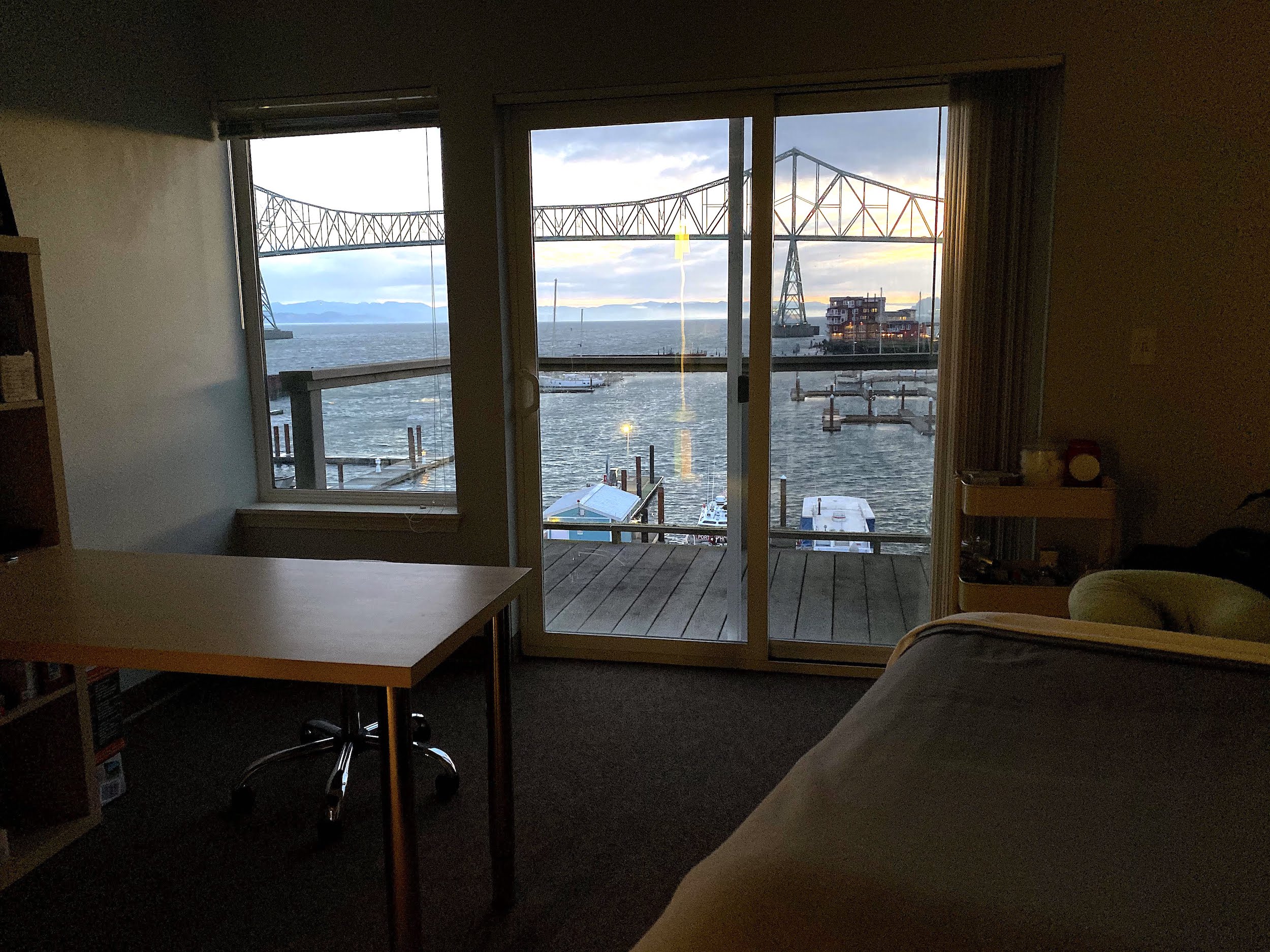 a darkened serene treatment room looking out over marina and bridge